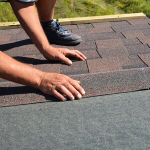 person installing asphalt roof